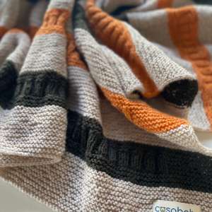 Handgestrickte gestreifte Babydecke