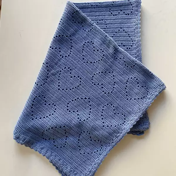 Hand-crocheted blue baby blanket with heart pattern made from soft breathable cotton. Lightweight summer blanket for baby boys or gender-neutral nursery – perfect baby shower gift or newborn photography prop.