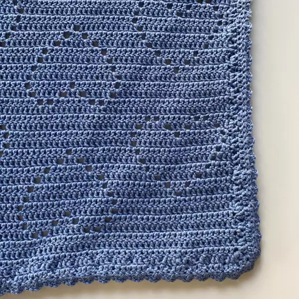 Hand-crocheted blue baby blanket with heart pattern made from soft breathable cotton. Lightweight summer blanket for baby boys or gender-neutral nursery – perfect baby shower gift or newborn photography prop.