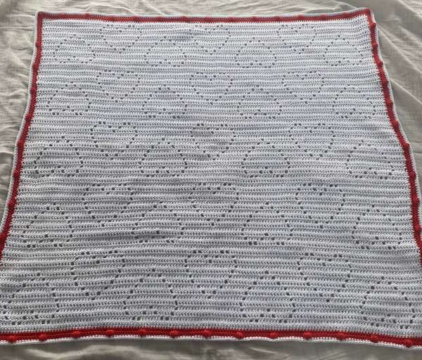 A romantic white crochet baby blanket made of breathable cotton yarn, with delicate heart-shaped patterns and a playful red edge – perfect for Valentine’s Day, springtime strolls, or newborn photo shoots. Soft, heirloom-worthy, and handmade with love.