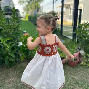Boho baby girl dress with hand-knit top and muslin skirt, organic cotton, soft and breathable, perfect for special occasions